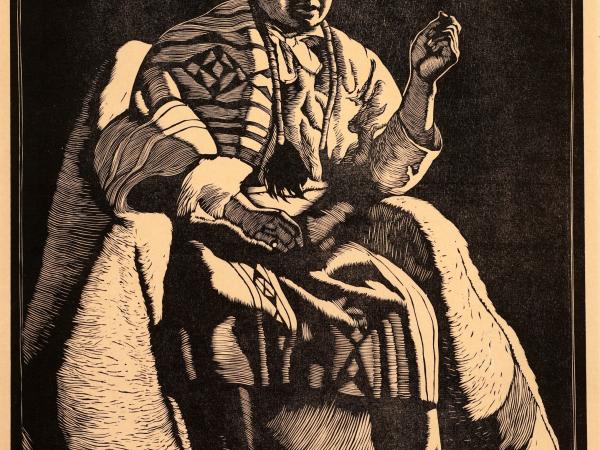 Large Native American man sitting in traditional wear