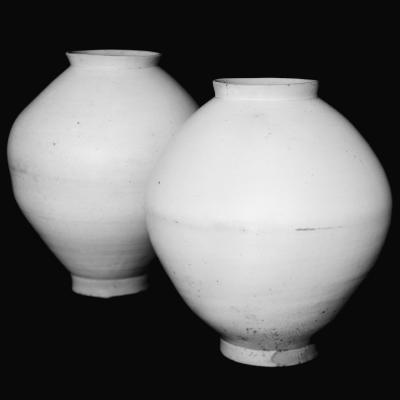 Two white Korean moon jars side by side