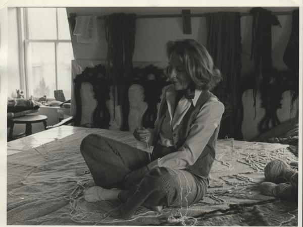 Nancy sitting on a tapestry