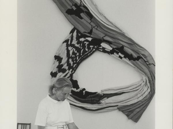 Nancy working with one of her art works behind her