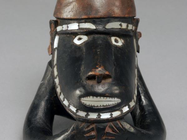 Statue made out of dark wood and pearl made to resemble a Native figure