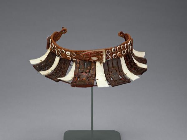 Brown and white headdress made out of turtle shell and coconut fiber
