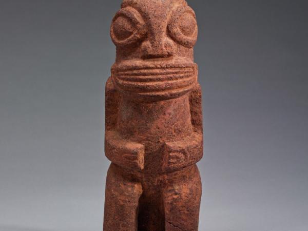 Small stone object of a figure with large eyes and clenched hands
